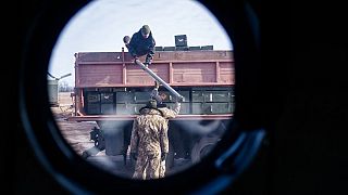 18th Separate Army Aviation Brigade unload a truck of ammunition before a sortie, in eastern Ukraine