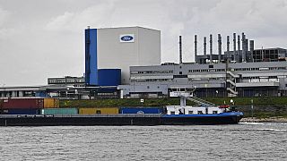 FILE - A container ship passes the Ford car plant in Cologne, Germany, May 4, 2020.