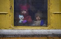 Children look out of the window of an unheated Lviv-bound train.