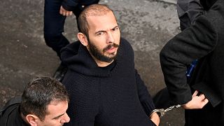  Andrew Tate arrives handcuffed and escorted by police at a courthouse in Bucharest on February 1, 2023 