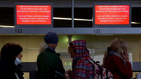 Lufthansa service staff talks to passengers after an IT fault. 