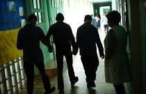 Residents walk along a corridor after lunch time in a facility for people with mental and physical disabilities in the village of Tavriiske, Ukraine, Tuesday, May 10, 2022.