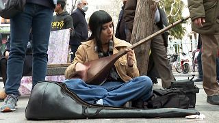 مونا در حال نواختن موسیقی در گوشه یکی از خیابان‌های تهران 