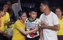 Duangpetch Promthepet (középen), az elárasztott barlangból kimentett egyik fiút a rokonai köszöntik otthonában, Thaiföldön, Chiang Rai tartományban, 2018. július 18-án..