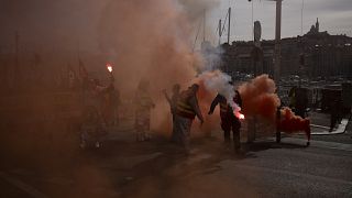 Protesters light flares during a demonstration in Marseille, southern France,