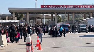 Des familles syriennes attendent au poste-frontière de Cilvegozu, en Turquie, pour pouvoir entrer en Syrie.