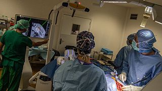  جراح يستخدم ذراعاً روبوتية لاجراء عملية لمريض مصاب بسرطان الثدي النقيلي، في المستشفى التابع لجامعة أنجيه، غرب فرنسا- 2021.