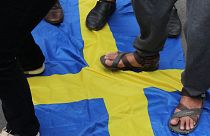 FILE: Activists step on the Swedish flag as demonstrators gather outside the Swedish Embassy in Jakarta on January 30, 2023,