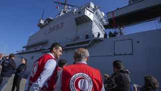 Members of the Syrian Arab Red Crescent oversee the unloading of containers of aid from the Italian Navy ship San Marco in the port of Beirut, Lebanon, 17 February 2023.