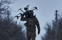 Ukrán katona drónnal a vállán az avdijikvai fronton