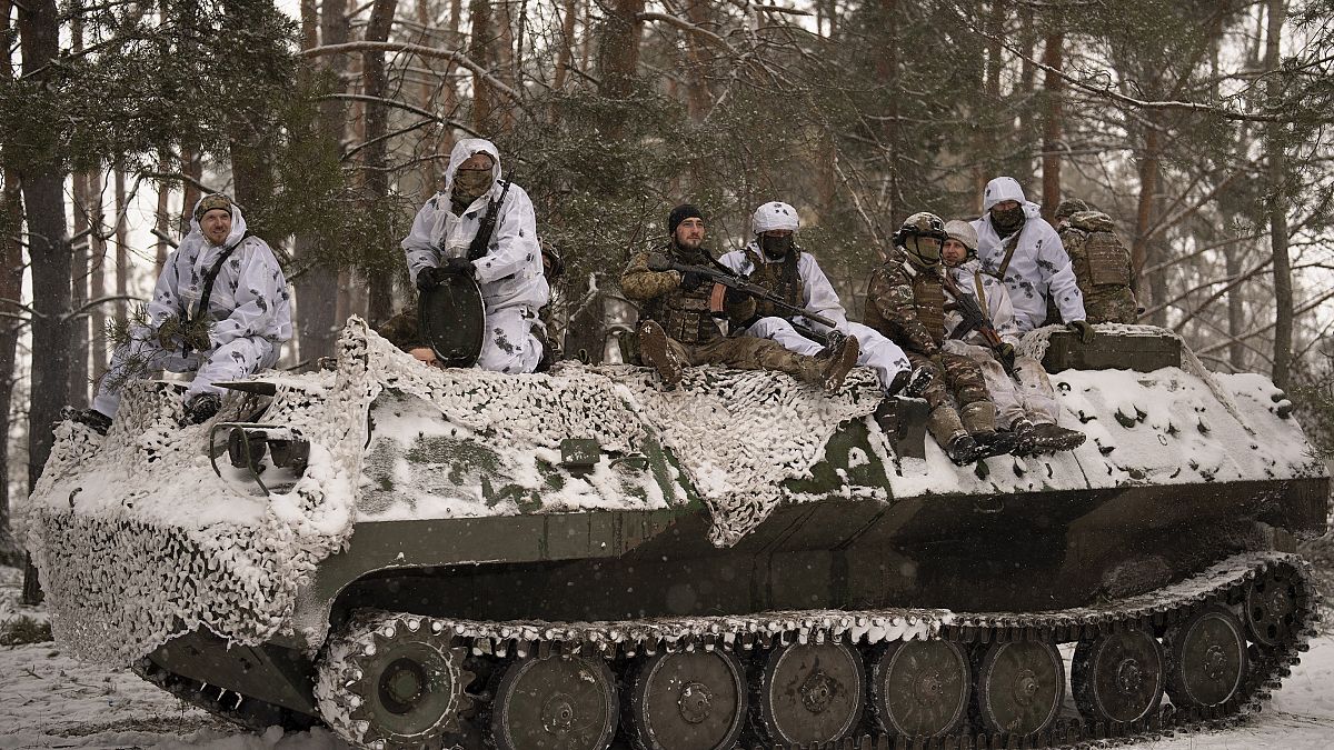 A frontra induló ukrán katonák egy páncélozott jármű tetején 2023. február 18-án.