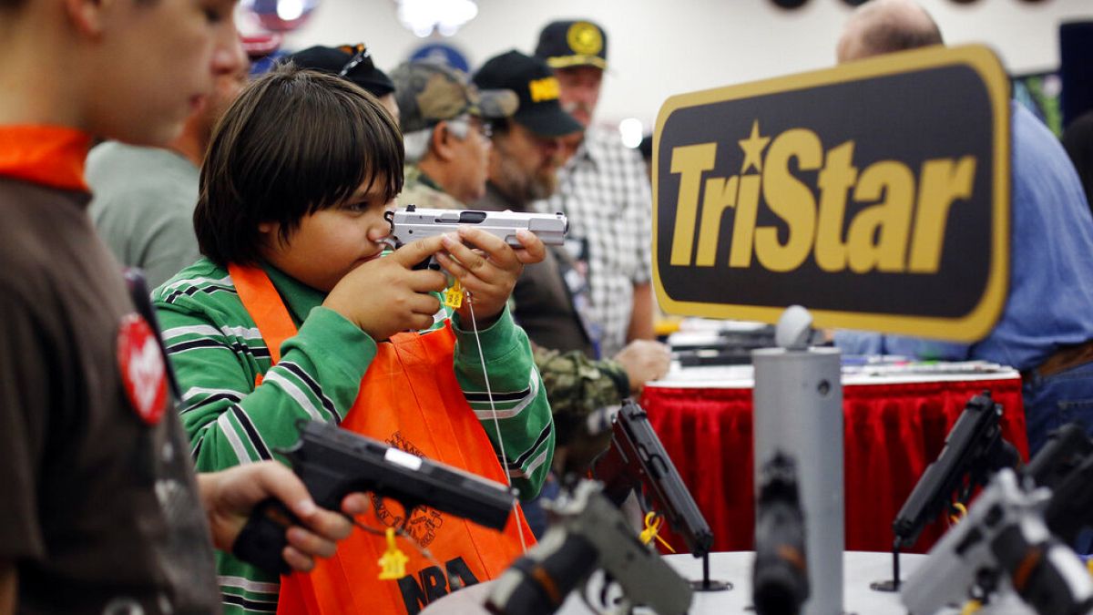 Gyerekek próbálgatnak fegyvereket az NRA (Nemzeti Lőfegyverszövetség) éves összejövetelén 2013-ban Houstonban