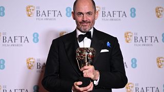 Edward Berger posiert mit seinem Bafta für den besten Regisseur - insgesamt hat sein Film 7 Baftas erhalten