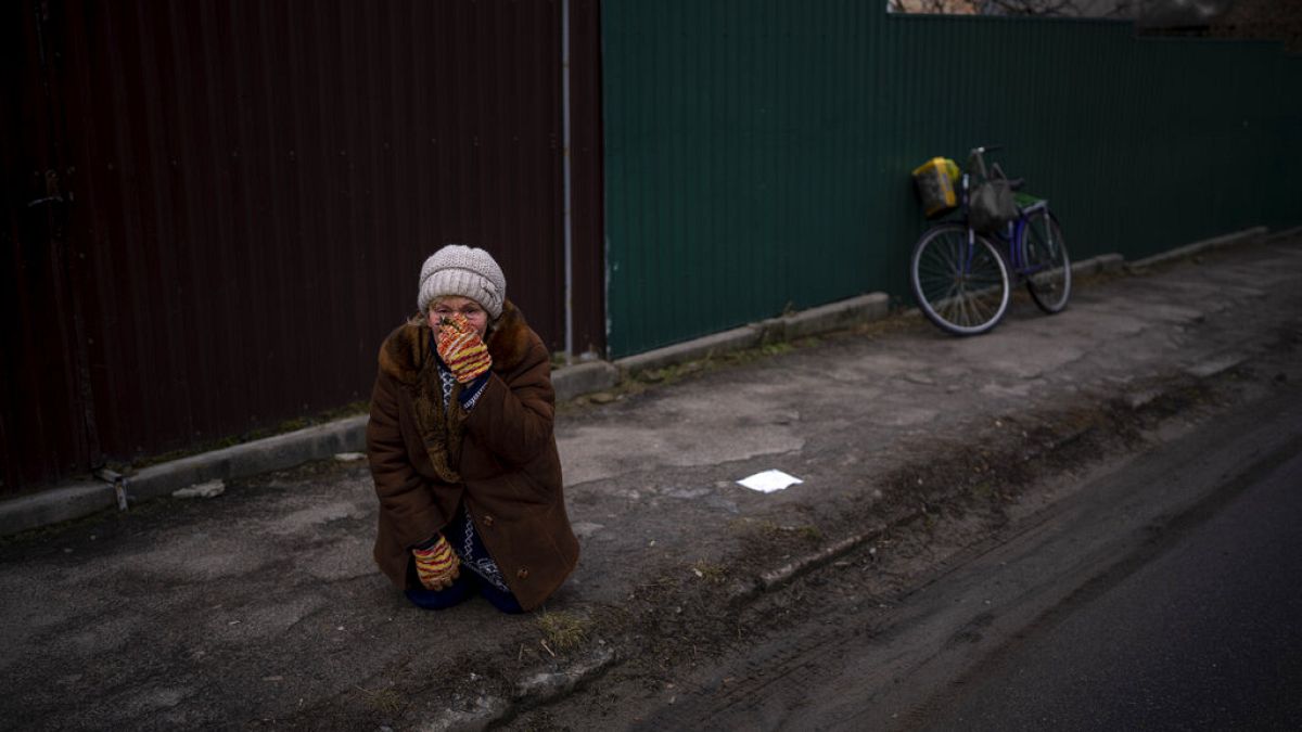 Женщина следит за похоронами 35-летнего Константина в Боровой, недалеко от Киева, Украина, суббота, 18 февраля 2023