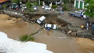 This photo provided by the Sao Paulo Government shows vehicles fallen from an elevated area along the beach in Sao Sebastiao, east of Sao Paulo, Brazil, Sunday, Feb. 19, 2023