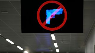 A television displays a "no guns" sign at the Transportation Security Administration security area at the Hartsfield-Jackson Atlanta International Airport on, Jan. 2 2023.