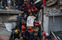 Turkish rescue workers carry a man to an ambulance after they pulled him out from a collapsed building.