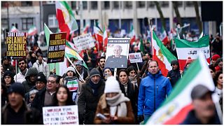 متظاهرون في بروكسل يرفعون العلم الإيراني أثناء مشاركتهم في احتجاج لدعم الاحتجاجات الإيرانية