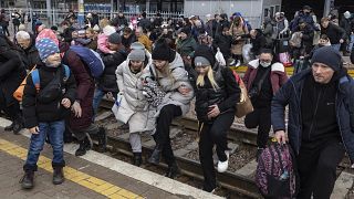 People, mostly women and children, try to get onto a train bound for Lviv, at the Kyiv railway station, Ukraine, Friday, March 4, 2022.