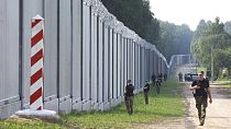 Polish border guards patrol the area of a newly built metal wall on the border between Poland and Belarus, near Kuznice, Poland, Thursday, June 30, 2022.