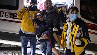 A boy is taken to an ambulance after being injured during the latest earthquake in Hatay, Turkey, Monday, Feb. 20, 2023. 