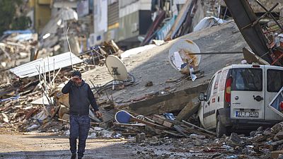 Ein Mann vor den Trümmern zerstörter Gebäude in Antakya
