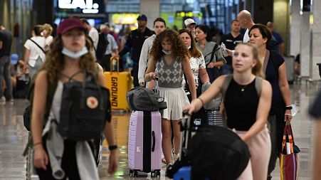 Travellers push their luggages at the Terminal 2 of El Prat airport in Barcelona.