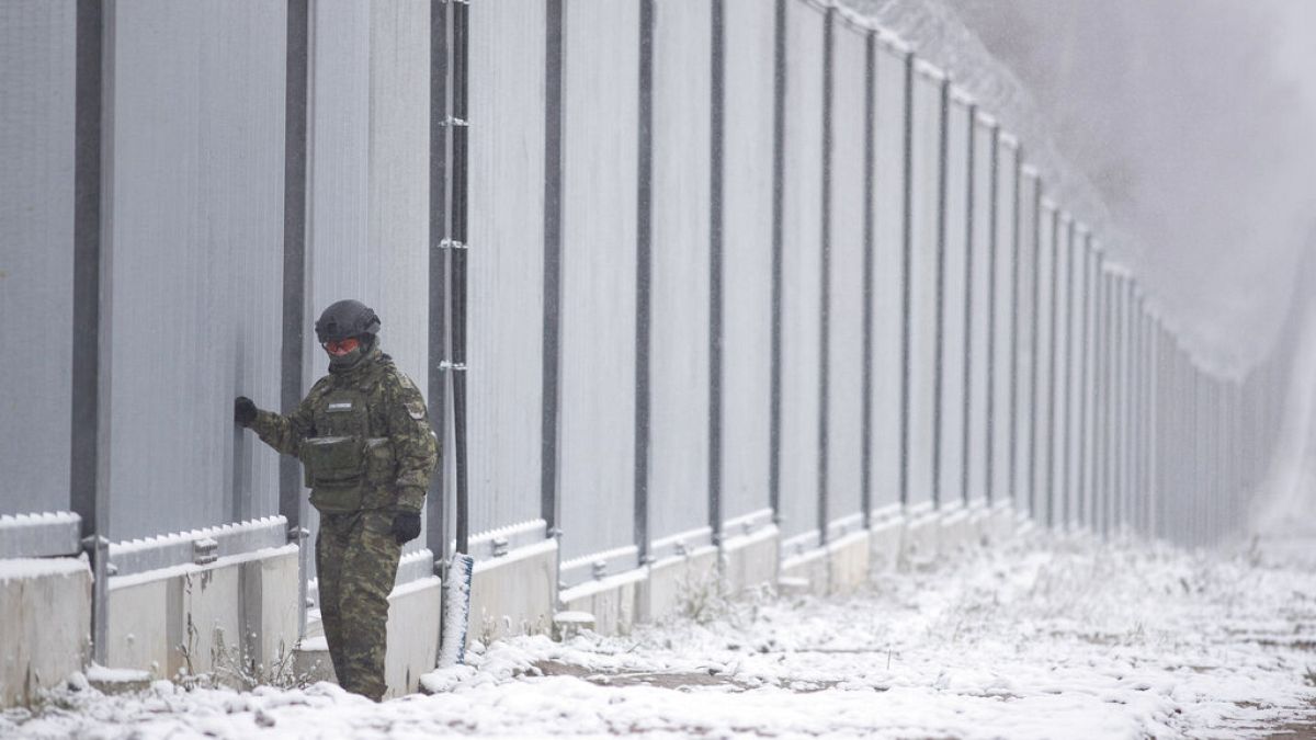 Polish border guard stands next to the border wall in Nomiki, Poland, Friday Nov, 2022.