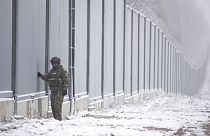 Polish border guard stands next to the border wall in Nomiki, Poland, Friday Nov, 2022.