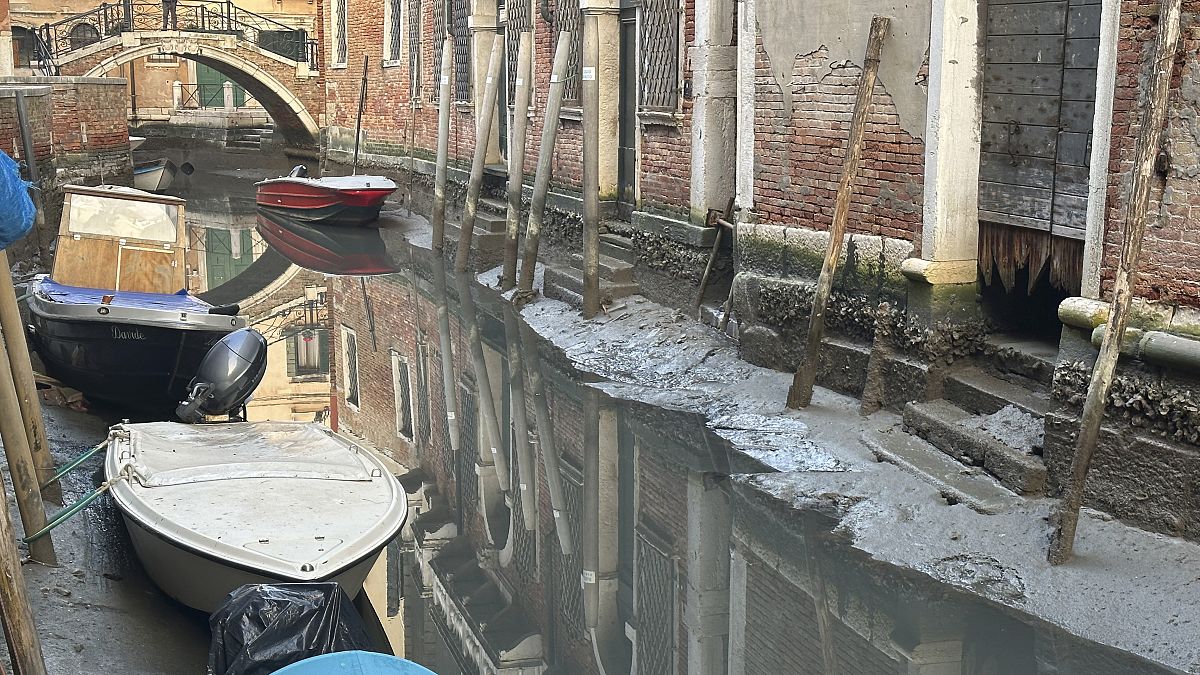 قوارب في قناة أثناء انخفاض المد في البندقية، إيطاليا فبراير 2023