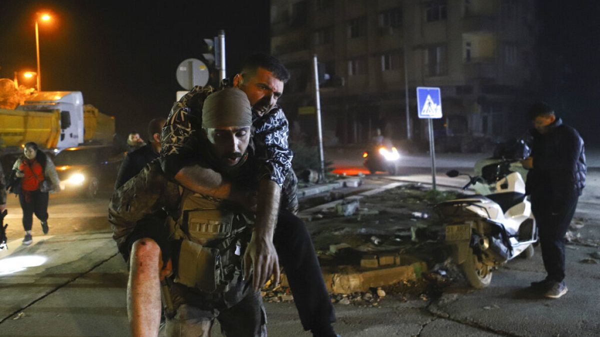 In Hatay trägt ein Soldat einen verletzten Mann