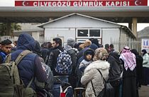 Syrians wait to cross into Syria from Turkey at the Cilvegozu border gate, near the town of Antakya, southeastern Turkey, Tuesday, Feb. 21, 2023.