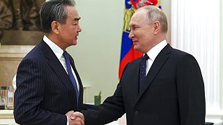 El ministro de Exteriores chino, Wang Yi, da la mano al presidente ruso, Vladímir Putin, durante su reunión en Moscú, Rusia