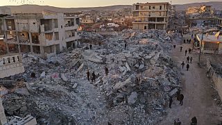 أشخاص بالقرب من المباني المنهارة بعد الزلزال المدمر في بلدة جنديريس بمحافظة حلب، سوريا، 9 فبراير، 2023.