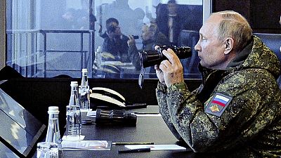 Президент России Владимир Путин в военной форме с биноклем