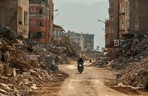 مردی سوار بر موتورسیکلت از کنار آوار ساختمان های ویران شده در سمندغ، جنوب ترکیه، چهارشنبه، ۲۲ فوریه ۲۰۲۳. 