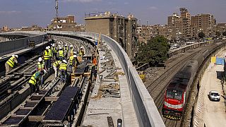 عمال بناء يعملون على مسارات موضوعة حديثا للخط الثالث لمترو القاهرة، في محطة إمبابة الجديدة بالجيزة، 18 أكتوبر 2022 .