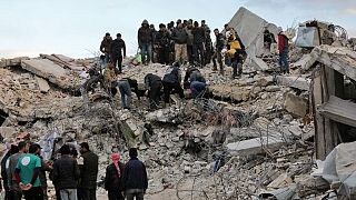 رجال إنقاذ ومدنيون سوريون يتجمعون في مبنى منهار، بلدة جنديريس، 7 شباط 2023 ، 