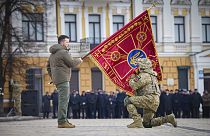 Президент Украины Владимир Зеленский c флагом воинской части в ходе церемонии в Киеве 24 фквраля 2023 г.