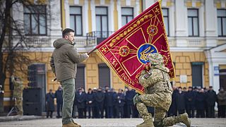 Президент Украины Владимир Зеленский c флагом воинской части в ходе церемонии в Киеве 24 фквраля 2023 г.