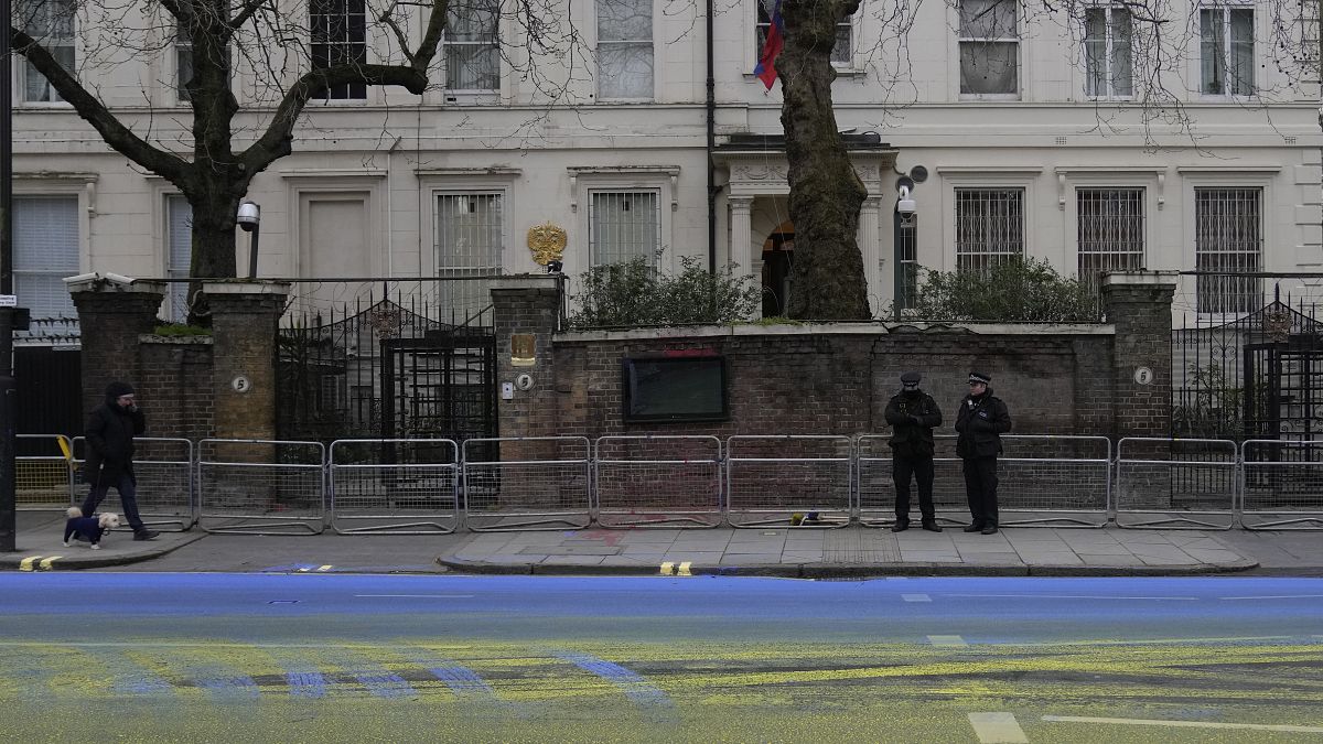  أشخاص من مجموعة "لِد باي دونكيز"، اليوم الخميس، العلم الأوكراني بالطلاء على الطريق المار خارج السفارة الروسية في العاصمة البريطانية، لندن.. 23 فبراير 2023.