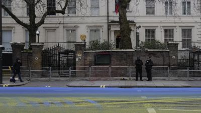  أشخاص من مجموعة "لِد باي دونكيز"، اليوم الخميس، العلم الأوكراني بالطلاء على الطريق المار خارج السفارة الروسية في العاصمة البريطانية، لندن.. 23 فبراير 2023.