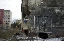 An artwork made by British street artist Banksy is seen at the bottom of a destroyed building in Irpin, near Kyiv, Ukraine, Wednesday, Feb. 22, 2023.