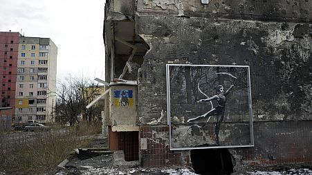 An artwork made by British street artist Banksy is seen at the bottom of a destroyed building in Irpin, near Kyiv, Ukraine, Wednesday, Feb. 22, 2023.