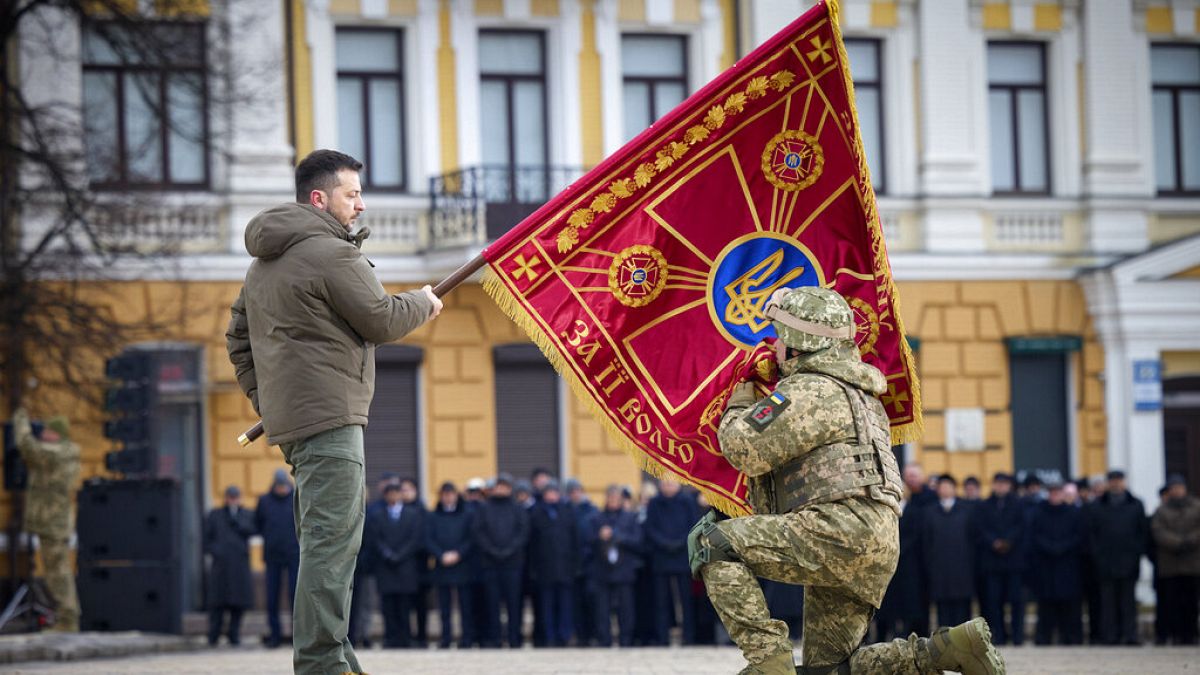 الرئيس الأوكرايحمل علم وحدة عسكرية بينما يقبله أحد الضباط، بمناسبة الذكرى السنوية الأولى للحرب الروسية الأوكرانية في كييف، أوكرانيا،24 فبراير 2023.