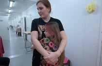 Tatjana Matjusenko egy kislányt ölel magához a bucsai ideiglenes otthonban. 