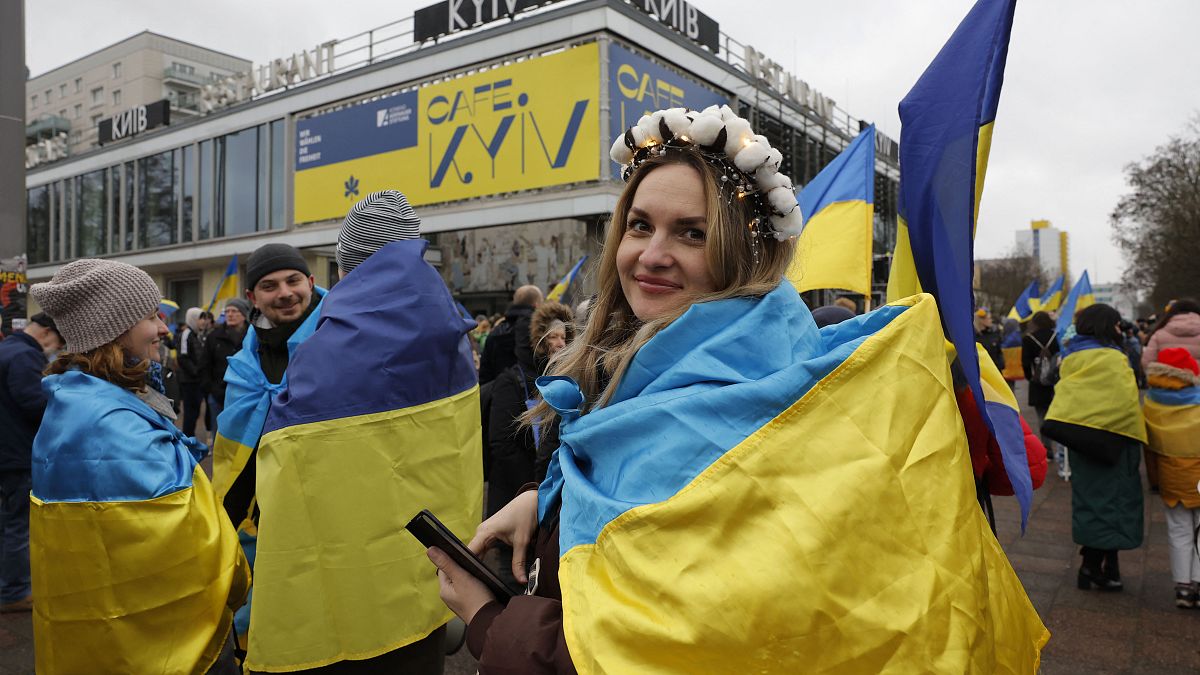 Eine Demonstrantin hat sich vor dem Berliner "Cafe Moskau" in eine ukrainische Flagge gewickelt.