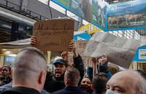 فرنسيون يحملون لافتات كتب عليها "مترو، عمل، قبر" أثناء احتجاجهم ضد رفع الحد الأدنى لسن التقاعد خلال زيارة ماكرون لمعرض باريس للفلاحة. 2023/02/25