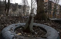 A part of a rocket sticks from a ground in front of a residential building which was heavily bombed by Russian forces in the frontline city of Vuhledar, Ukraine, Saturday, Feb