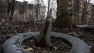 A part of a rocket sticks from a ground in front of a residential building which was heavily bombed by Russian forces in the frontline city of Vuhledar, Ukraine, Saturday, Feb